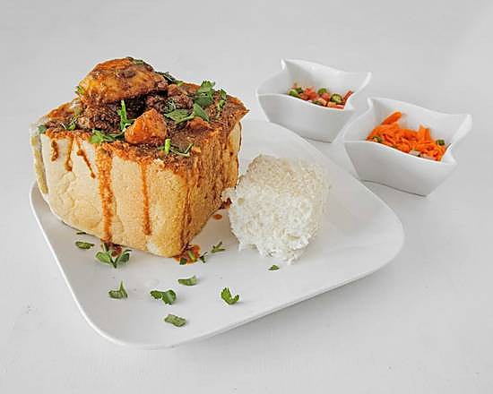 Lamb bunny chow, a hollowed bread loaf filled with slow-cooked curry